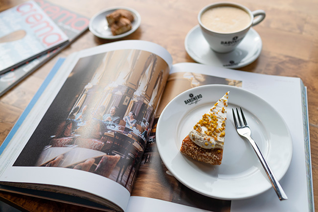 Eine Tasse Cafe Creme mit Kuchen und