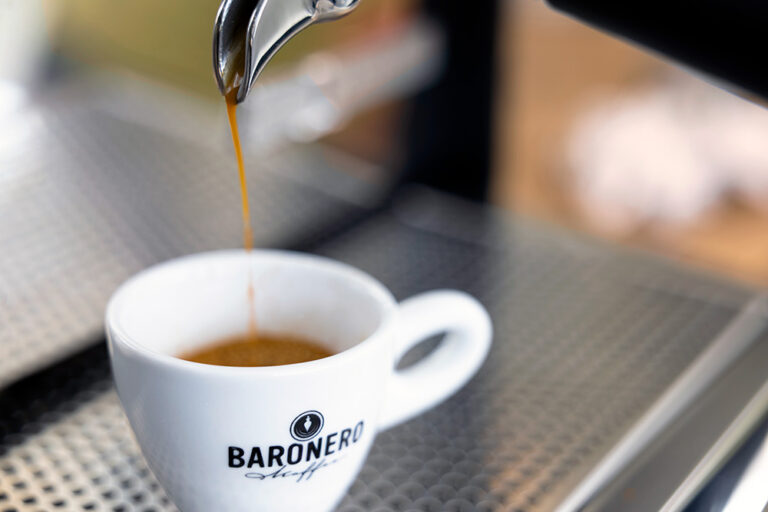 Espressotasse unter einem Siebträger, in die ein Espresso läuft